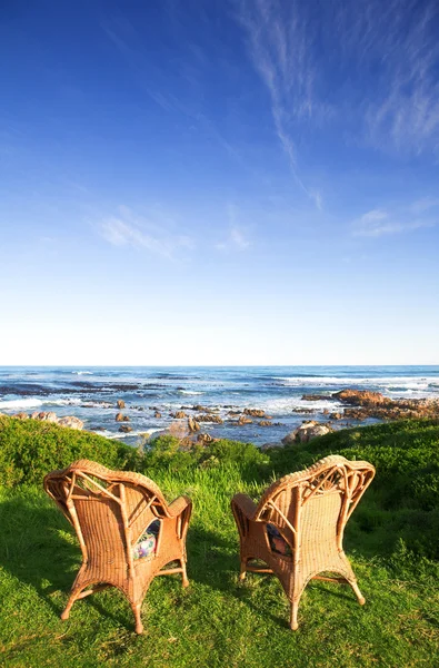 在靠海的草坪上柳条藤桌椅 — 图库照片