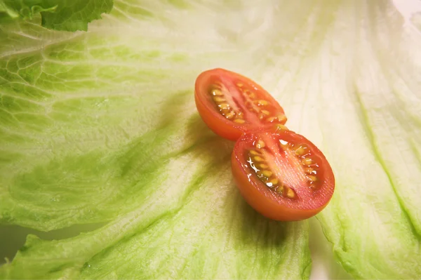 Cherry tomato on a leaf of lettuce — Stock Photo, Image