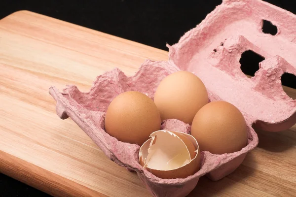 Eggs in an eggholder on a wooden cutting board — Stock Photo, Image