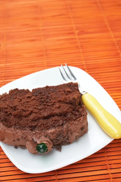 Slice of fresh chocolate cake with a small fork — Stock Photo, Image