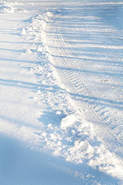 Tracks of a vehicle on a road in Munich covered insnow — Stock Photo, Image