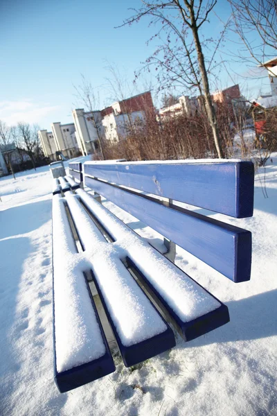 Panchina coperta di neve in un parco a Munch . — Foto Stock