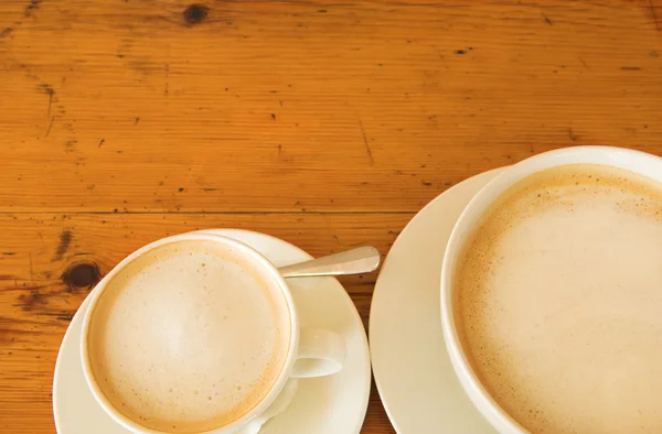 Två koppar kaffe på ett träbord — Stockfoto