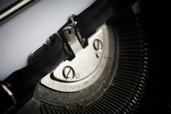 A Closeup image of the typebars and ribbon of an old style typewriter and paper — Stock Photo, Image