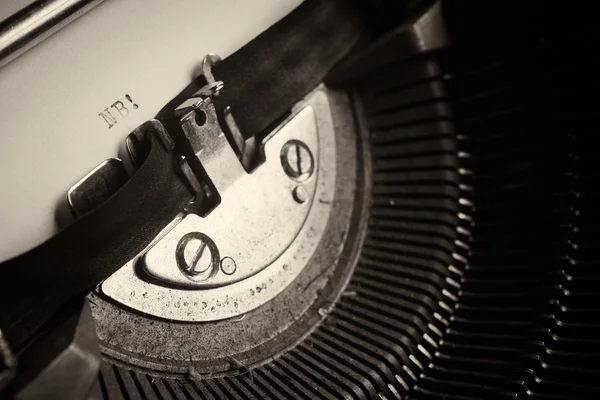 A Closeup image of the typebars and ribbon of an old style typewriter and paper — Stock Photo, Image