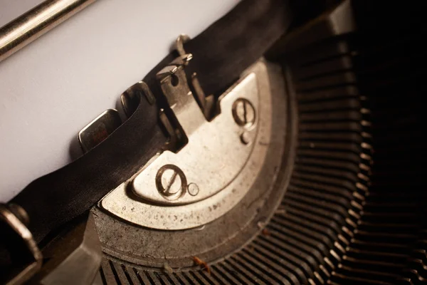 A Closeup image of the typebars and ribbon of an old style typewriter and paper — Stock Photo, Image