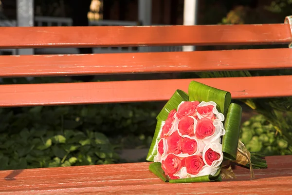 Červená růže svatební kytice na dřevěnou lavici — Stock fotografie