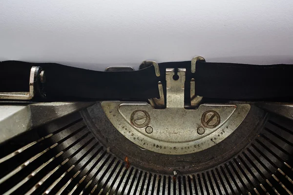 A Closeup image of the typebars and ribbon of an old style typewriter and paper — Stock Photo, Image