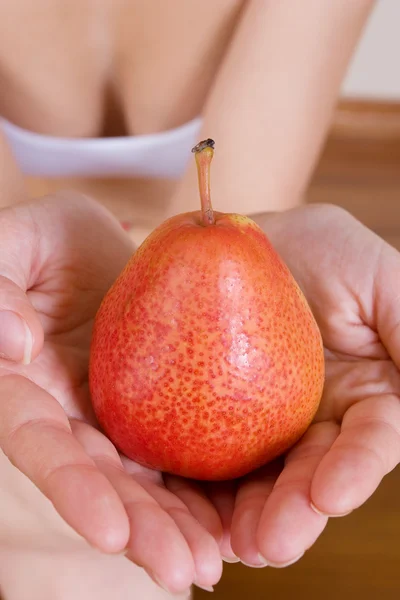 Close-up of female hands holding a pear — Stock Photo, Image