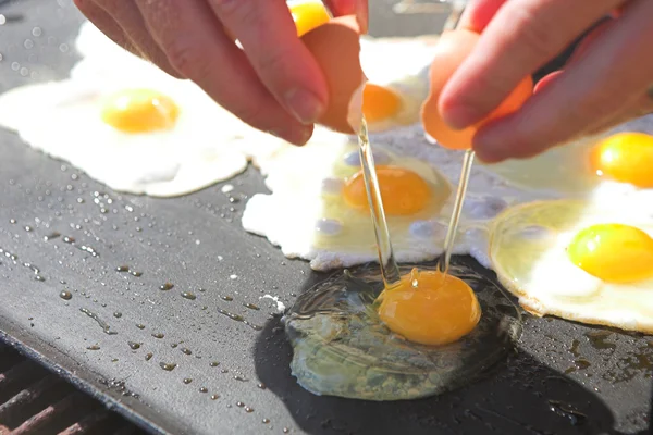 Fresh eggs being fried sunny side up on a large frying pan — Stock Photo, Image