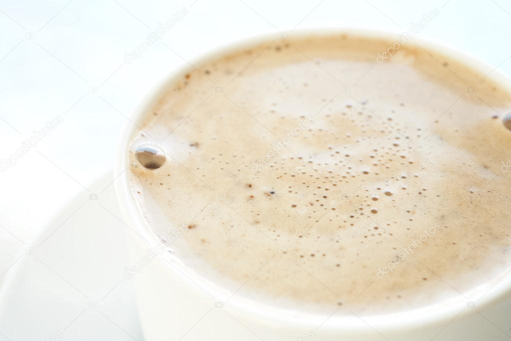Fresh foamy cafe latte in white coffee cup