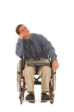 Tekerlekli sandalyede oturan bir dizüstü bilgisayarda çalışan adam.