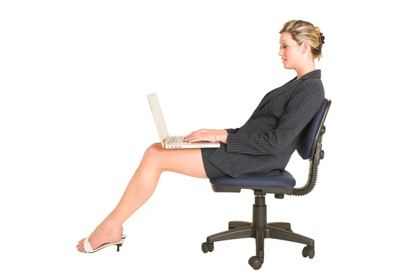 Femme d'affaires sur chaise de bureau avec ordinateur portable sur ses genoux — Photo