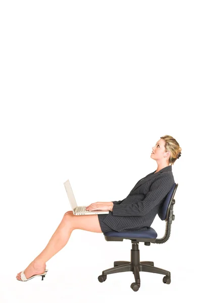 Mujer de negocios sentada en una silla de oficina con un portátil en su regazo —  Fotos de Stock