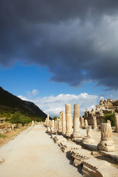 Pilastri e collinette accanto alla strada principale nelle antiche rovine della città di Efeso nella moderna Turchia — Foto Stock