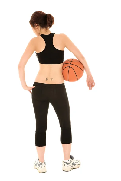 Mujer caucásica en un traje de entrenamiento negro con una pelota de baloncesto — Foto de Stock