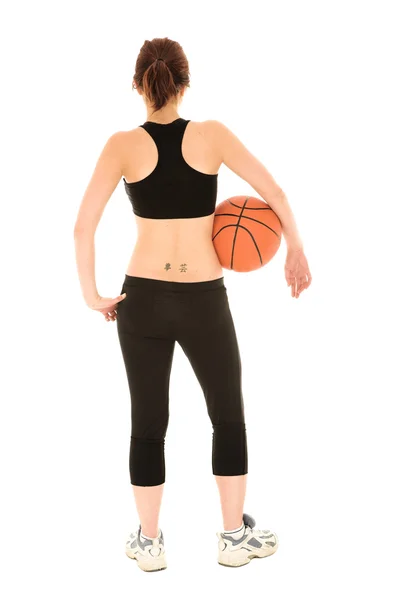 Mujer caucásica en un traje de entrenamiento negro con una pelota de baloncesto — Foto de Stock