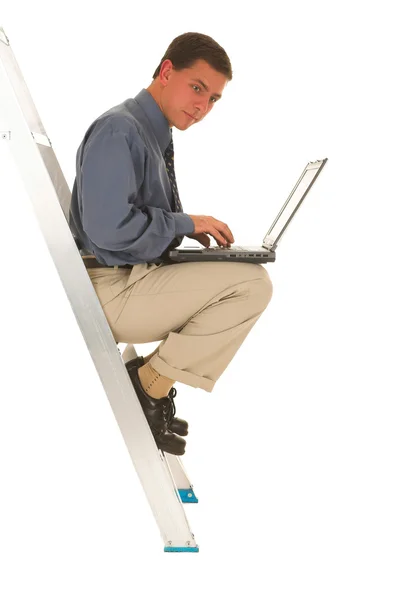 Man sitting on ladder working on laptop — Stock Photo, Image