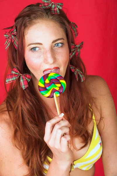 Jonge vrouwelijke volwassen mannequin met een grote veelkleurige lolly — Stockfoto