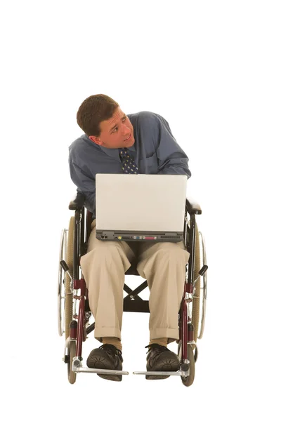 Muž sedící na vozíku pracují na přenosném počítači. — Stock fotografie