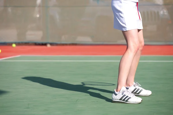 Piernas de una joven jugando al tenis — Foto de Stock