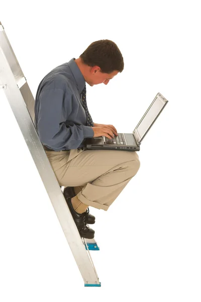 Man zit op de ladder die op laptop werkt. — Stockfoto