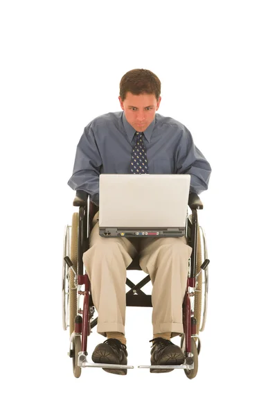 Hombre trabajando en un portátil sentado en una silla de ruedas . — Foto de Stock