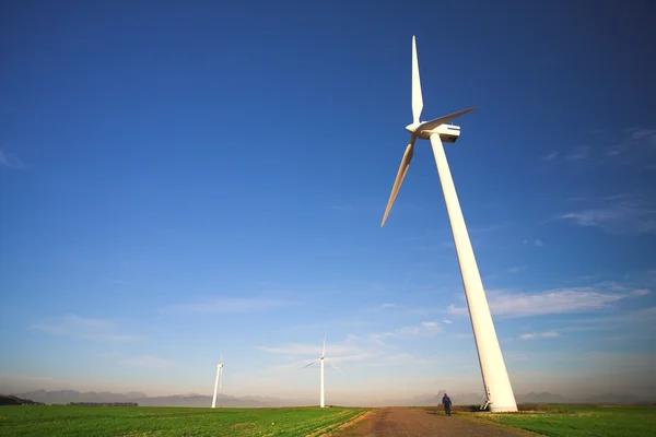 Wind powered electricity generator standing against the blue sky — Stock Photo, Image