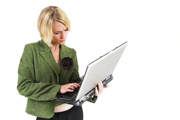 Zakelijke vrouw groene jas, die op laptop werkt — Stockfoto