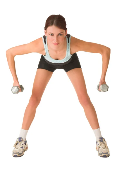 Woman standing, bending forward holding gym weights in both hands. — Stock Photo, Image