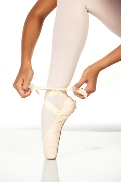 Joven bailarina de ballet mostrando cómo atar un zapato de punto de ballet —  Fotos de Stock