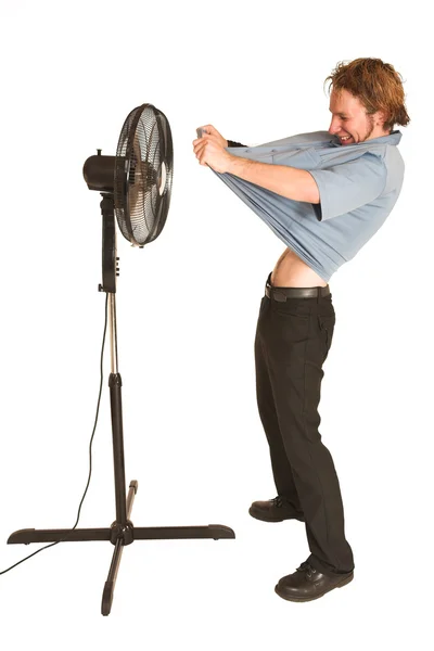 Man with blue shirt cooling down in front of a fan — Stock Photo, Image