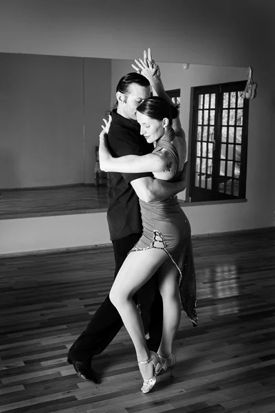 Een jonge volwassen paar dansen en het beoefenen van ballroom dansen samen in een studio — Stockfoto