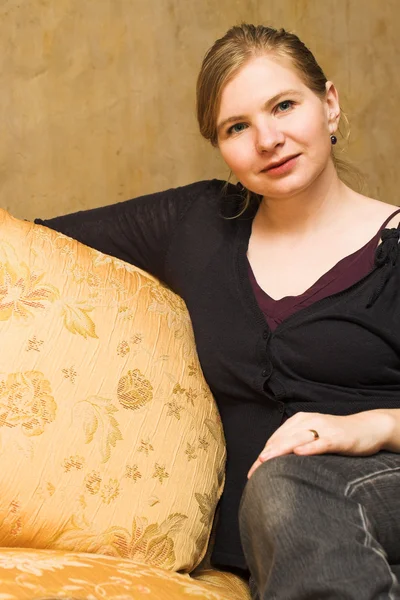 Felnőtt nő ül kényelmesen a luxus kanapén — Stock Fotó