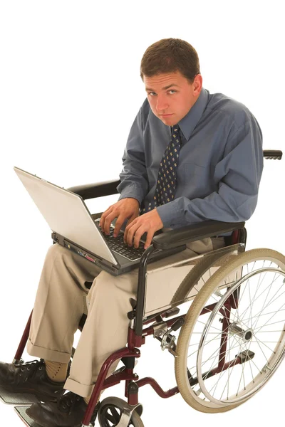 Businessman sitting in a wheelchair working on laptop — Stock Photo, Image