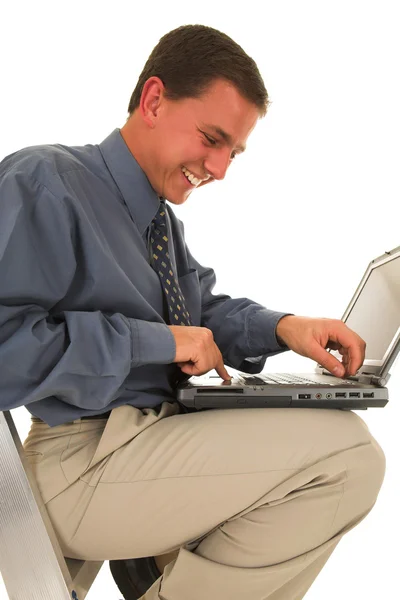 Man sitting on ladder working on laptop Stock Image