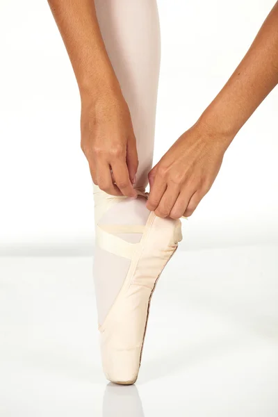 若い女性のバレエ ダンサー バレエ pointe の靴を結ぶ方法を示す ロイヤリティフリーのストック画像
