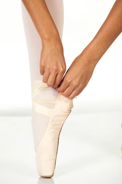 若い女性のバレエ ダンサー バレエ pointe の靴を結ぶ方法を示す ストック写真