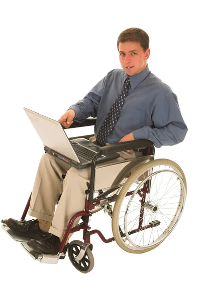 Businessman sitting in a wheelchair working on laptop — Stock Photo, Image