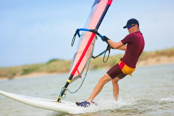 Snel bewegende windsurfer op het water op keurbooms lagune, Zuid-Afrika. — Stockfoto