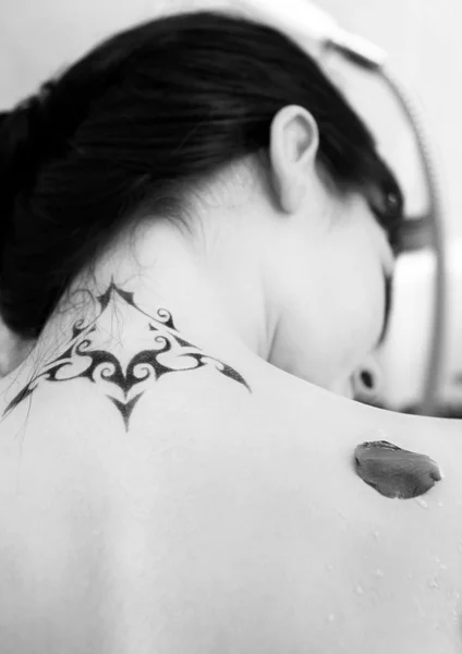 Mujer desnuda en un baño con tatuaje en la espalda . — Foto de Stock
