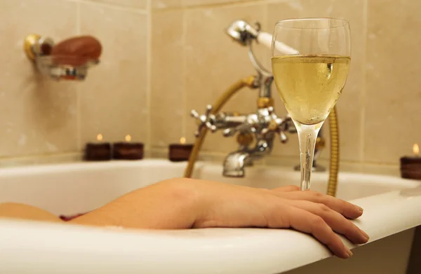 Woman in a bath, holding a champagne glass. — Stock Photo, Image
