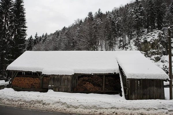 Pequeño granero de leña cubierto de nieve en los Alpes alemanes — Foto de Stock