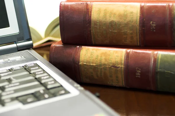 Ordenador portátil y libros legales en la mesa — Foto de Stock