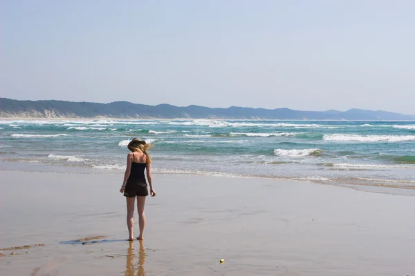 Una mujer caminando por la playa — Foto de Stock
