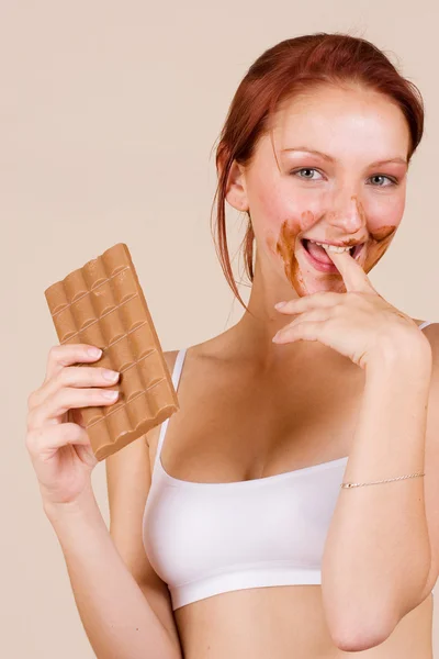 Roodharige meisje eten van chocolade — Stockfoto