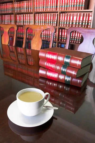 Белая чашка кофе с юридической библиотекой — стоковое фото