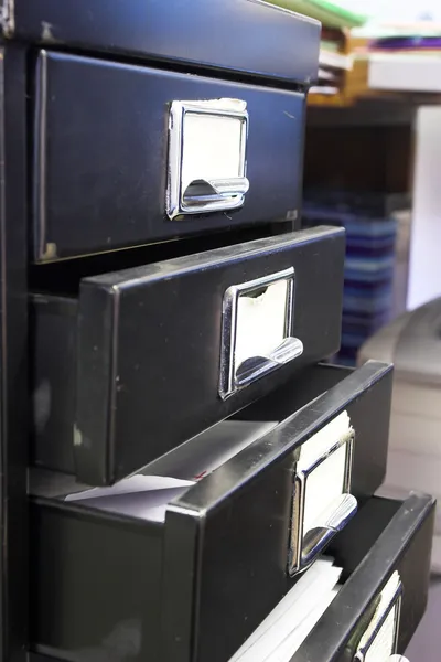 黑色迷你文件柜和带有四个打开抽屉的标签的特写 — 图库照片