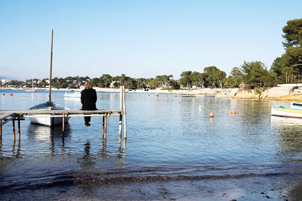 En person som sitter på en brygga i antibes, Frankrike. kopia utrymme. — Stockfoto