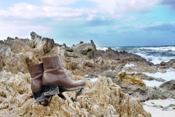 Brown leather boots on the rocks at the sea — Stock Photo, Image